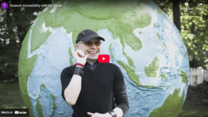 thumbnail of Museum Accessibility with Cai Steele featuring Cai standing in front of a globe statue outside.